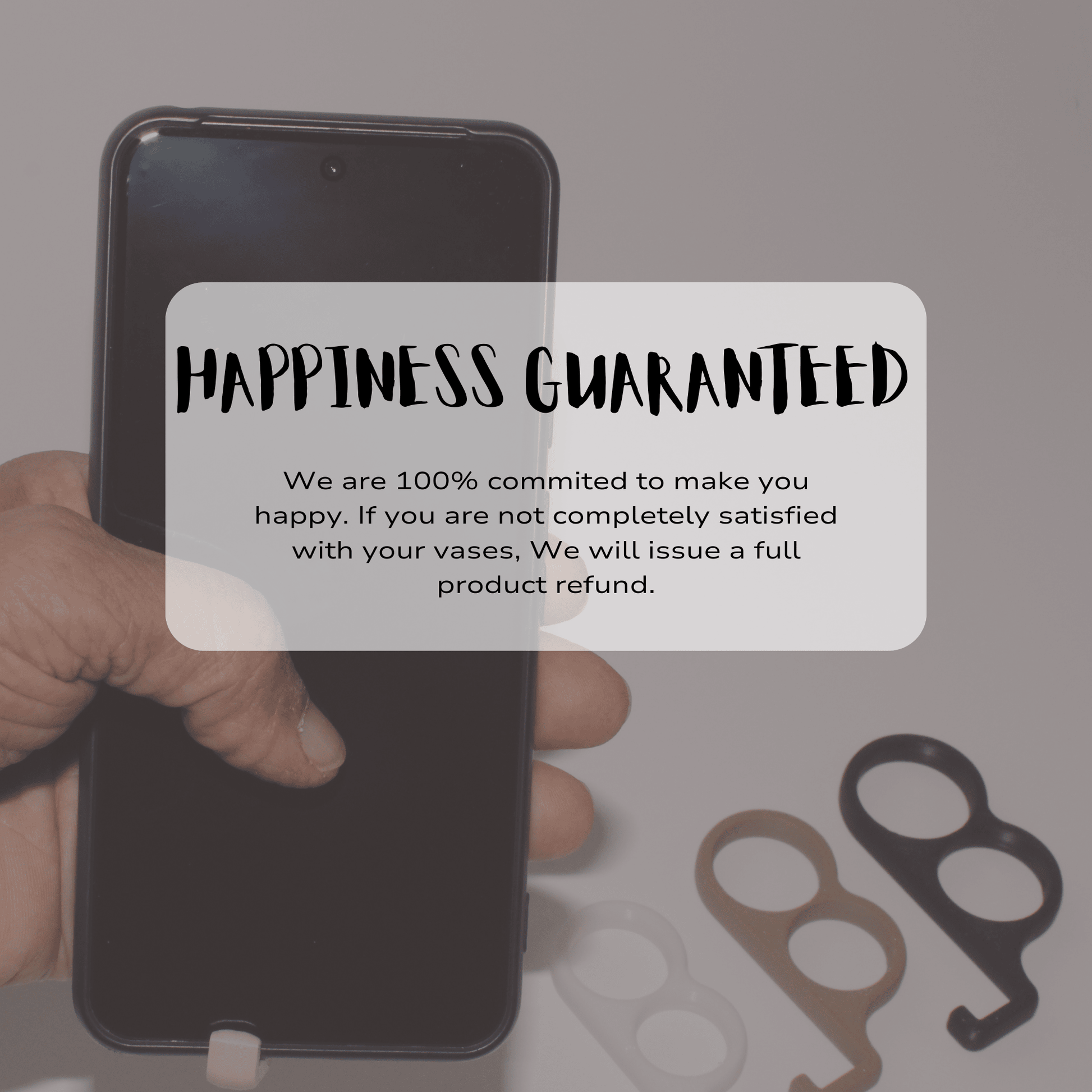 Hand holding a smartphone with a 'Happiness Guaranteed' text overlay on a blurred background.