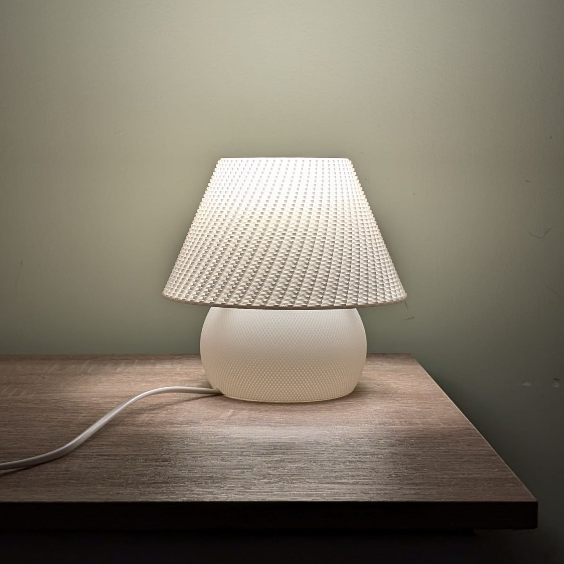 White textured table lamp on a wooden surface with a neutral background